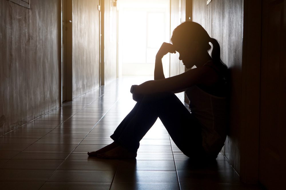 Silhouette of lonely girl sitting